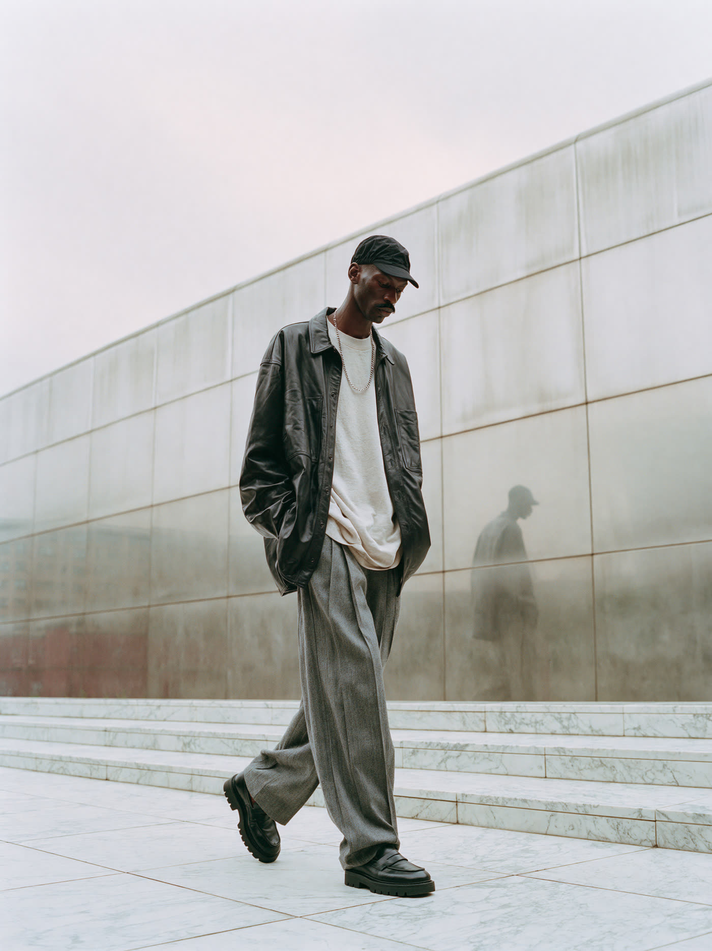 Man walking along the steel wall