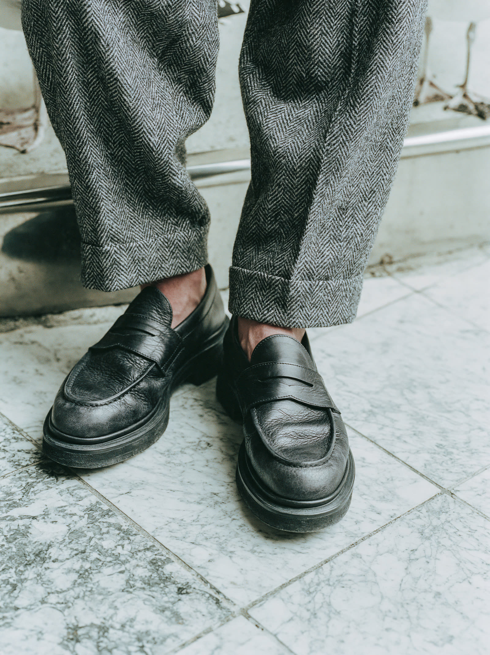 Detail of black loafers on marble