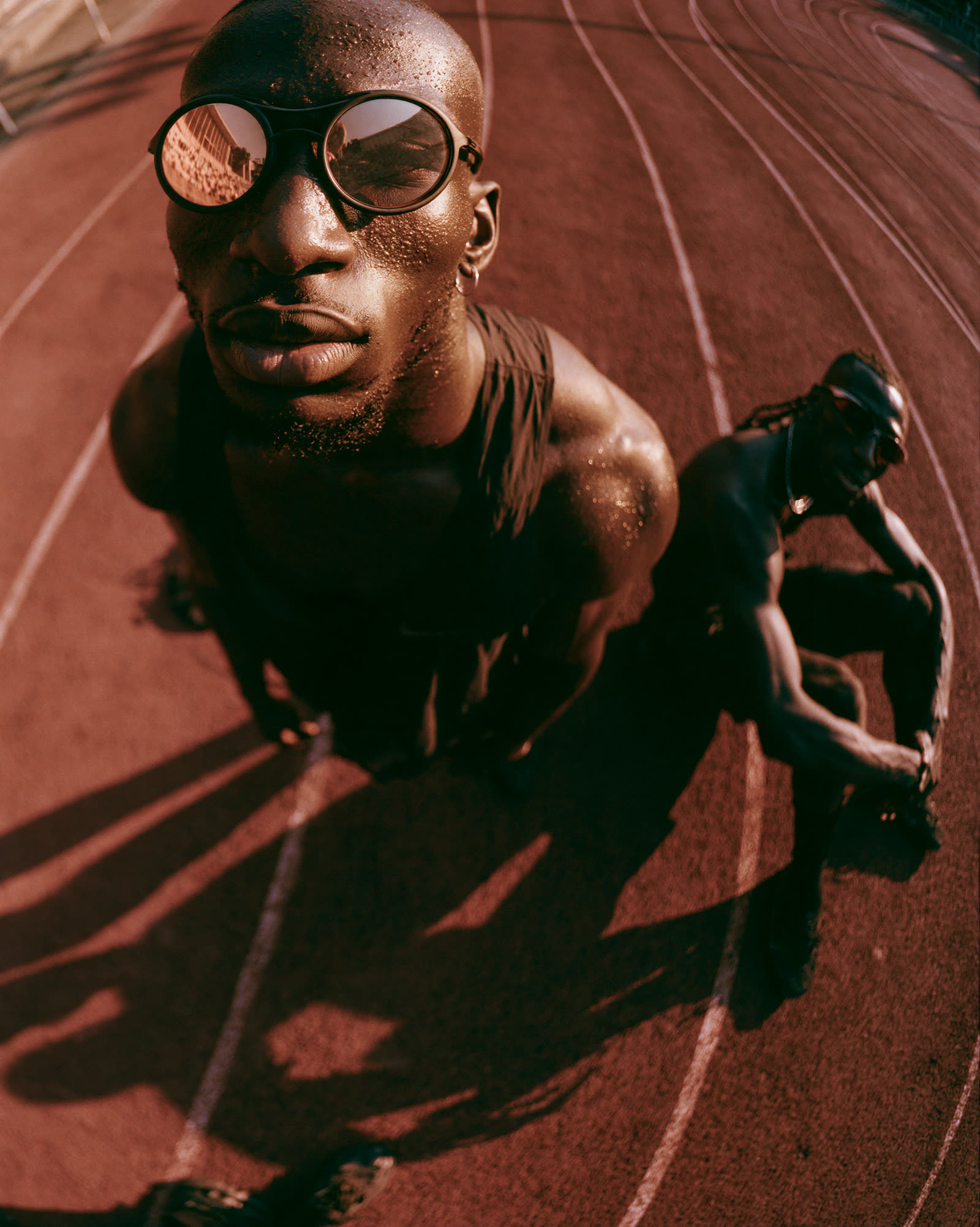 High-angle of a runner in retro sunglasses on a red track