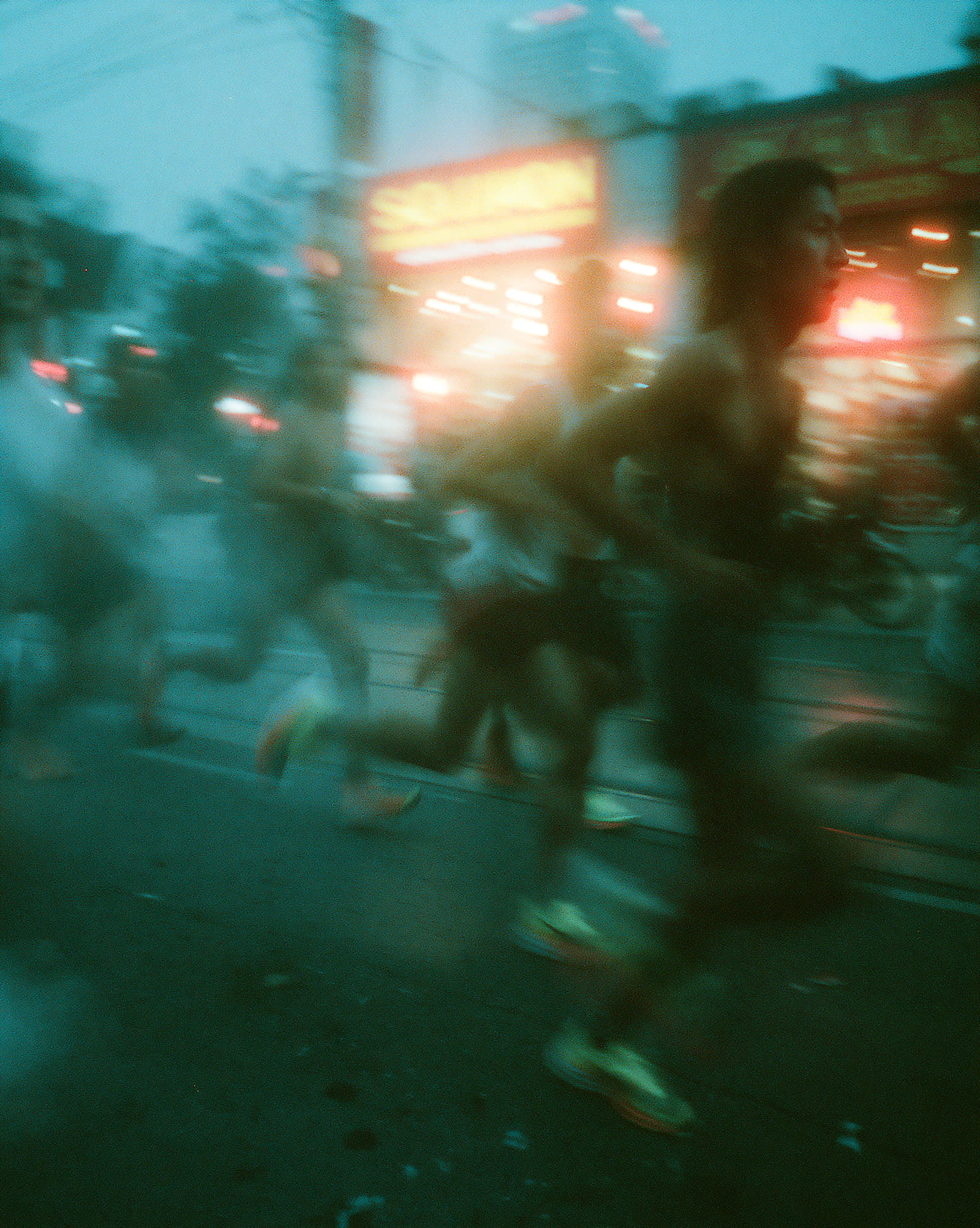 Panning shot of runners blurred in teal night light